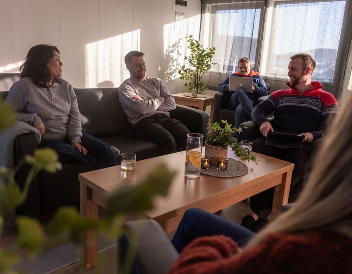 En gruppe mennesker nyter en hyggelig stund i et fellesområde.