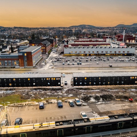 Anleggshotell med parkeringsplass og by i bakgrunnen