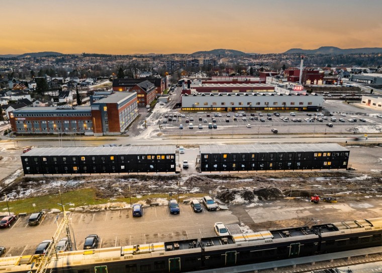 Anleggshotell med parkeringsplass og by i bakgrunnen