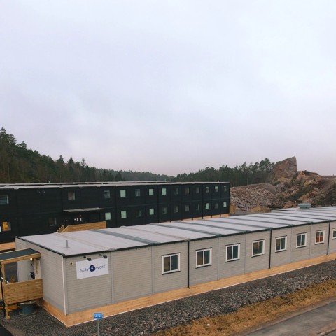 Bygninger på en høyde med skog bak