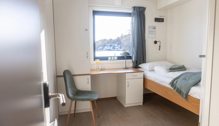 Single room with a desk, chair, and window view. Bedding and towels included.