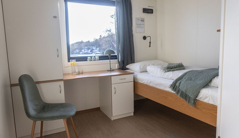 Single room with a desk, chair, and window view. Bedding and towels included.