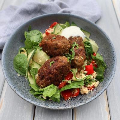 Koftas and couscous salad with spinach, cucumber, tomatoes, and a white sauce. Koftas and couscous salad with spinach, cucumber, tomatoes, and a white sauce.