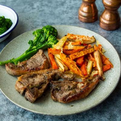 Plate with three lamb chops, roasted sweet potato and parsnip fries, and broccoli. Plate with three lamb chops, roasted sweet potato and parsnip fries, and broccoli.