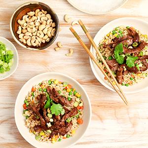 two plates of food with forks and spoons on a table .