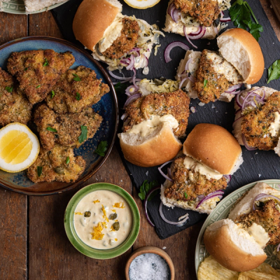 a table topped with plates of food and a bowl of sauce .