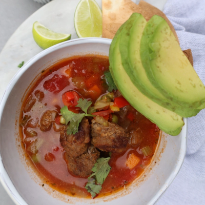 a bowl of soup with avocado slices on top a bowl of soup with avocado slices on top