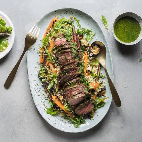 a plate of food with a steak , carrots , rice and vegetables on a table . a plate of food with a steak , carrots , rice and vegetables on a table .