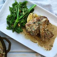 a white plate topped with meat and vegetables on a table . a white plate topped with meat and vegetables on a table .