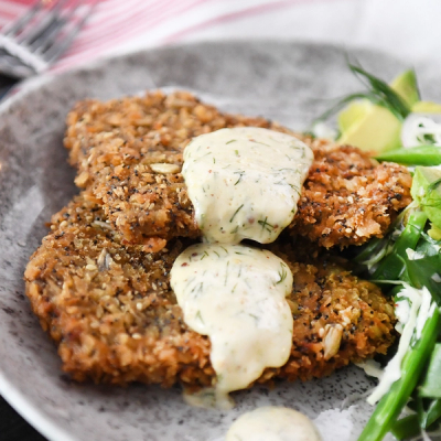 a plate of food with fried chicken and a salad on a table . a plate of food with fried chicken and a salad on a table .