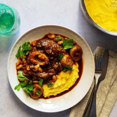 a plate of food with mashed potatoes, meat and beans on a table . a plate of food with mashed potatoes, meat and beans on a table .