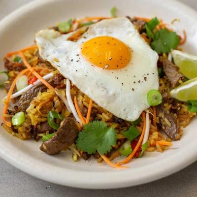 a close up of a plate of food with a fried egg on top . a close up of a plate of food with a fried egg on top .