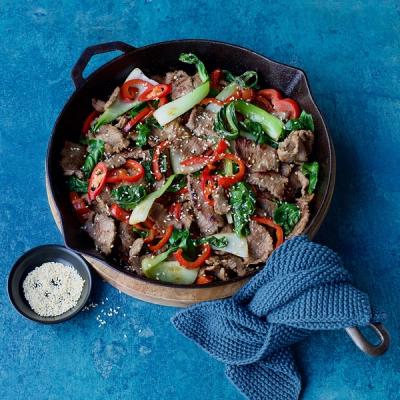 lamb stir-fry with red peppers, bok choy, and sesame seeds in a cast iron skillet. lamb stir-fry with red peppers, bok choy, and sesame seeds in a cast iron skillet.