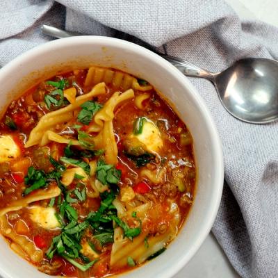 a bowl of soup with noodles and a spoon in it . a bowl of soup with noodles and a spoon in it .
