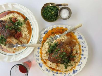 two plates of food with forks and spoons on a table .