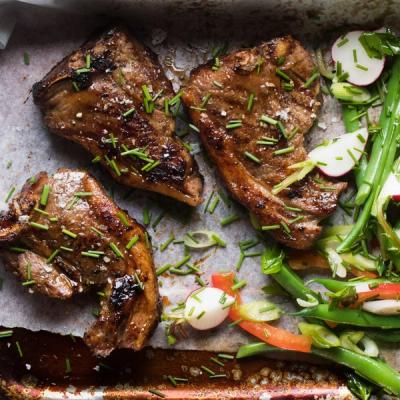 Three lamb chops with chives and salt, served with green beans and radishes. Three lamb chops with chives and salt, served with green beans and radishes.