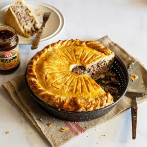 a pie with a slice taken out of it is in a pan on a table.