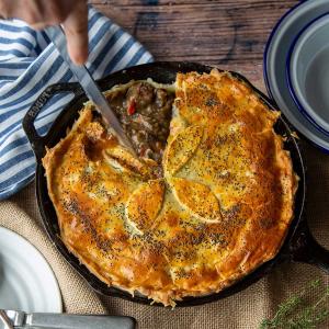 a family sized pie on a table with a slice being cut out of it a family sized pie on a table with a slice being cut out of it