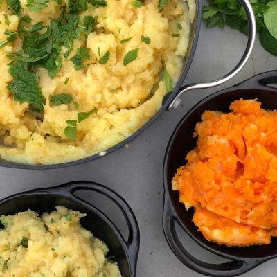 a bowl of mashed potatoes and a bowl of mashed sweet potatoes on a table . a bowl of mashed potatoes and a bowl of mashed sweet potatoes on a table .