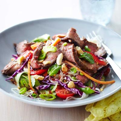 a close up of a plate of food with meat and vegetables on a table . a close up of a plate of food with meat and vegetables on a table .