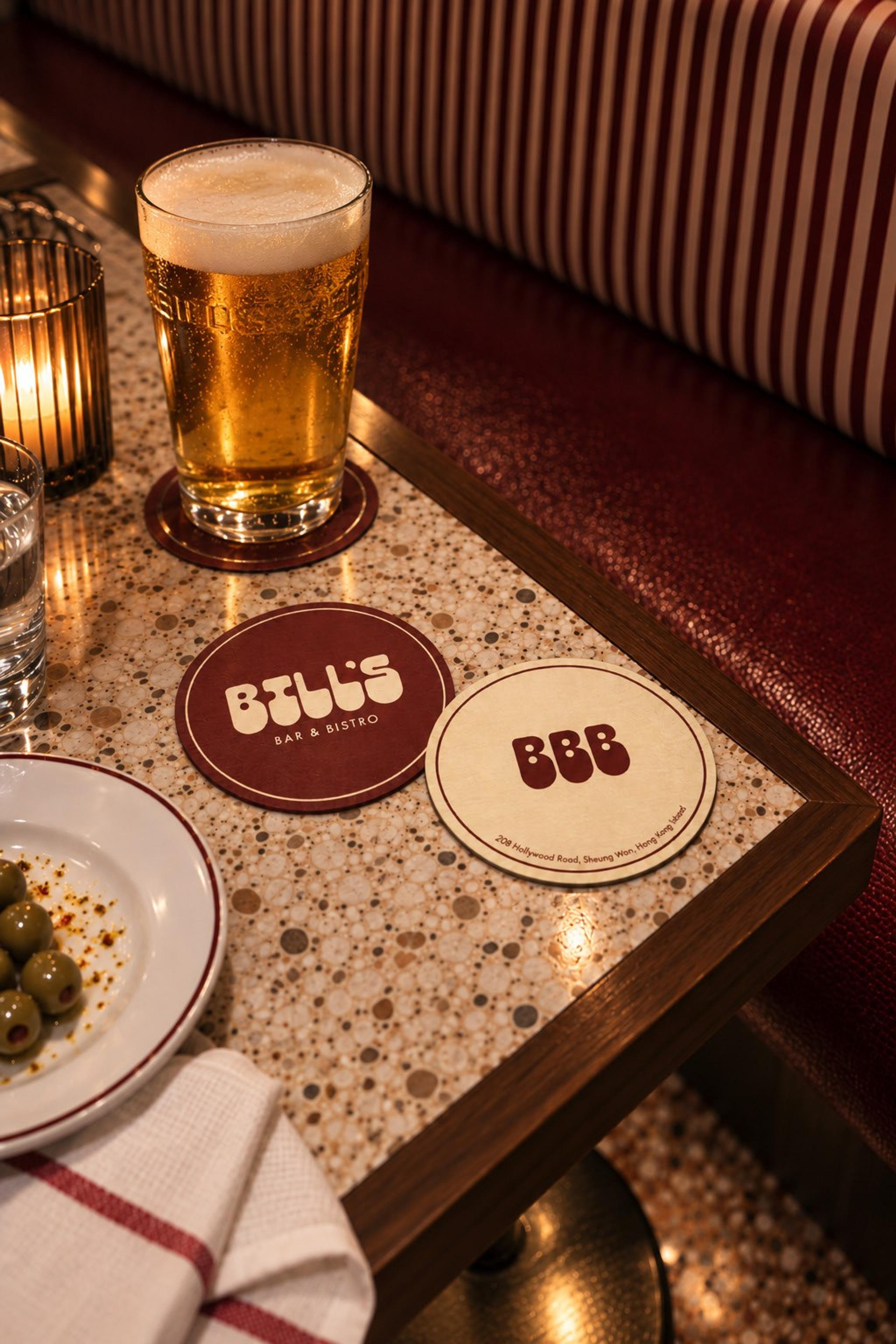 A cold beer on a Bill’s coaster at the end of a terrazzo table