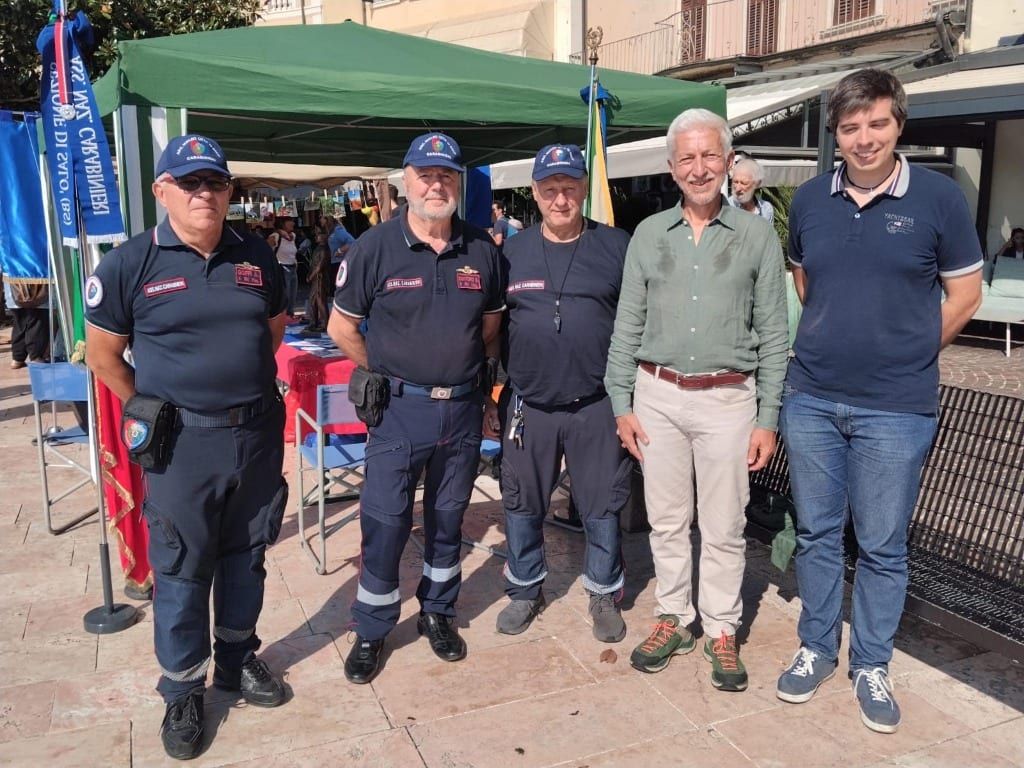 Volontari del Nucleo ANC di Salò in divisa e cittadini in visita al gazebo durante la manifestazione 100 Associazioni