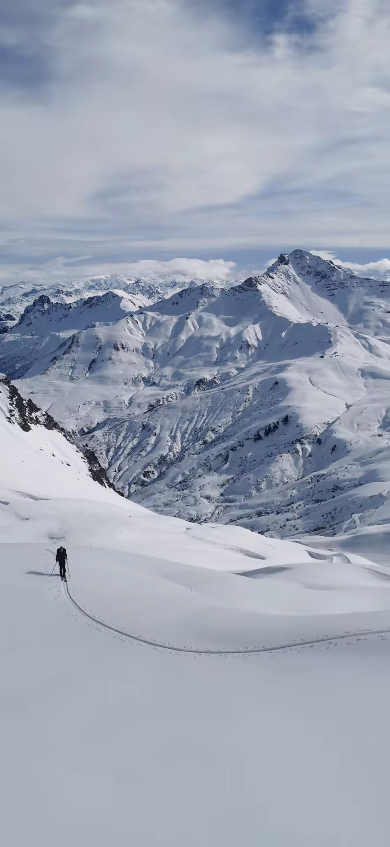 A Skieur à la montée dans l'immensité des montagnes de la Tarentaise