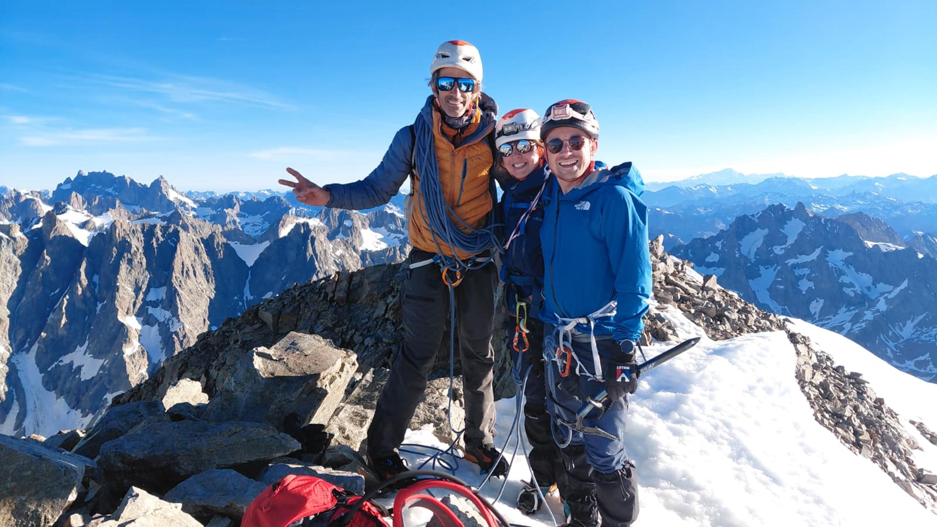 Le guide et ses deux clients posent heureux au sommet du Pelvoux, panorama sur les ECrins