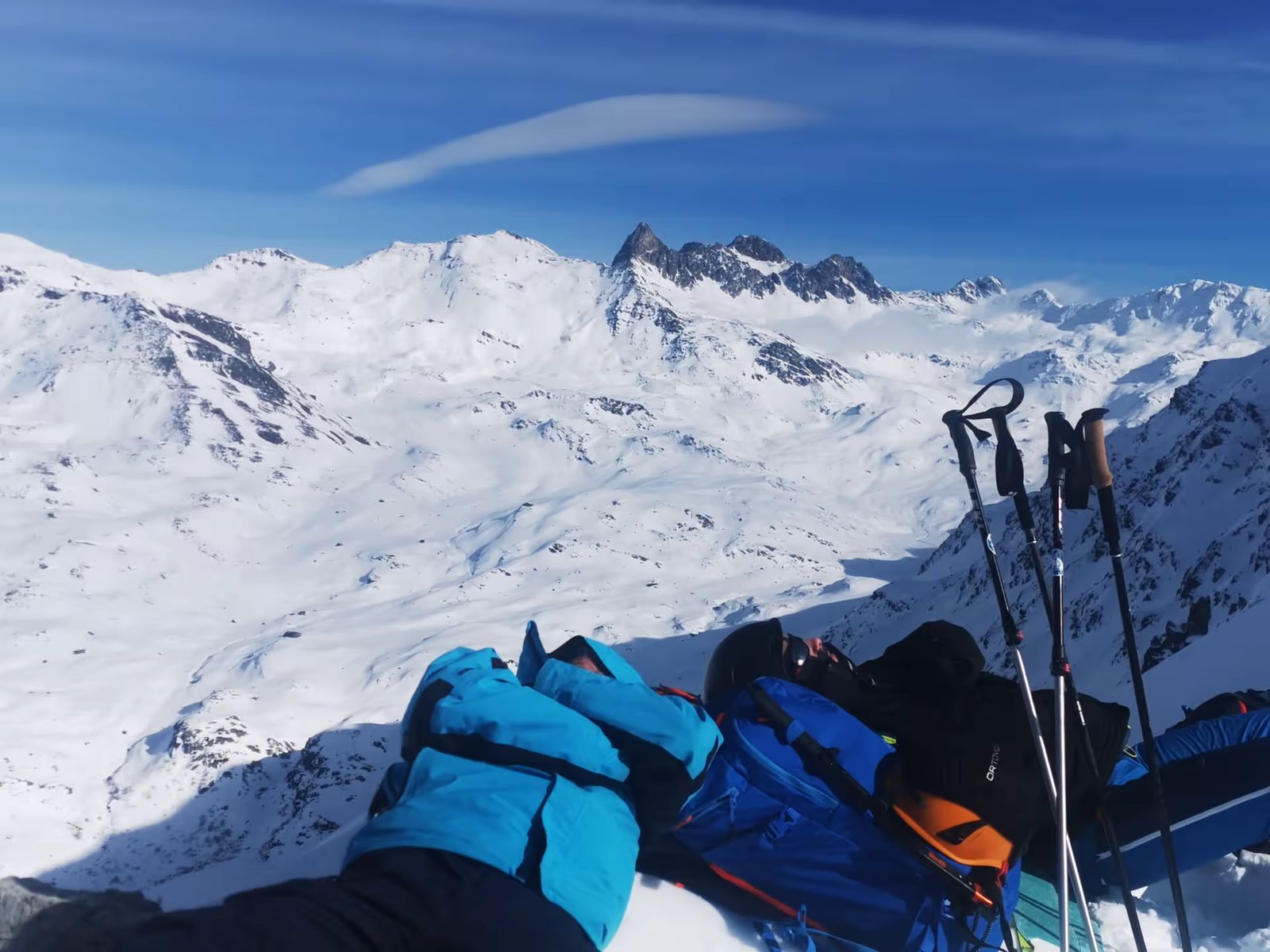 Pause sieste face aux sommets enneigés pendant un raid à ski dans les Cerces