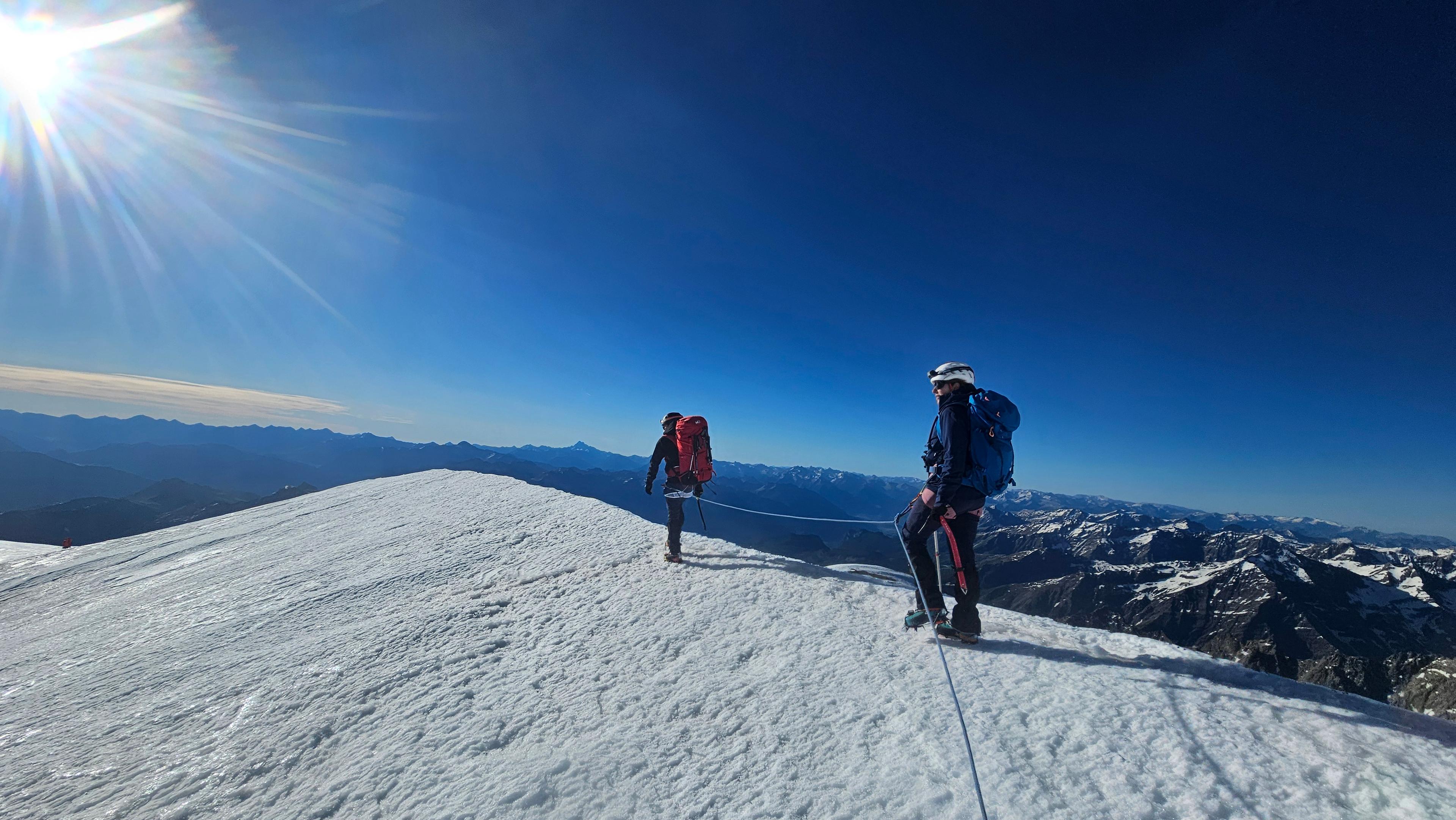 Cordée sur l'arête sommitale enneigée du Pelvoux, massif des Écrins