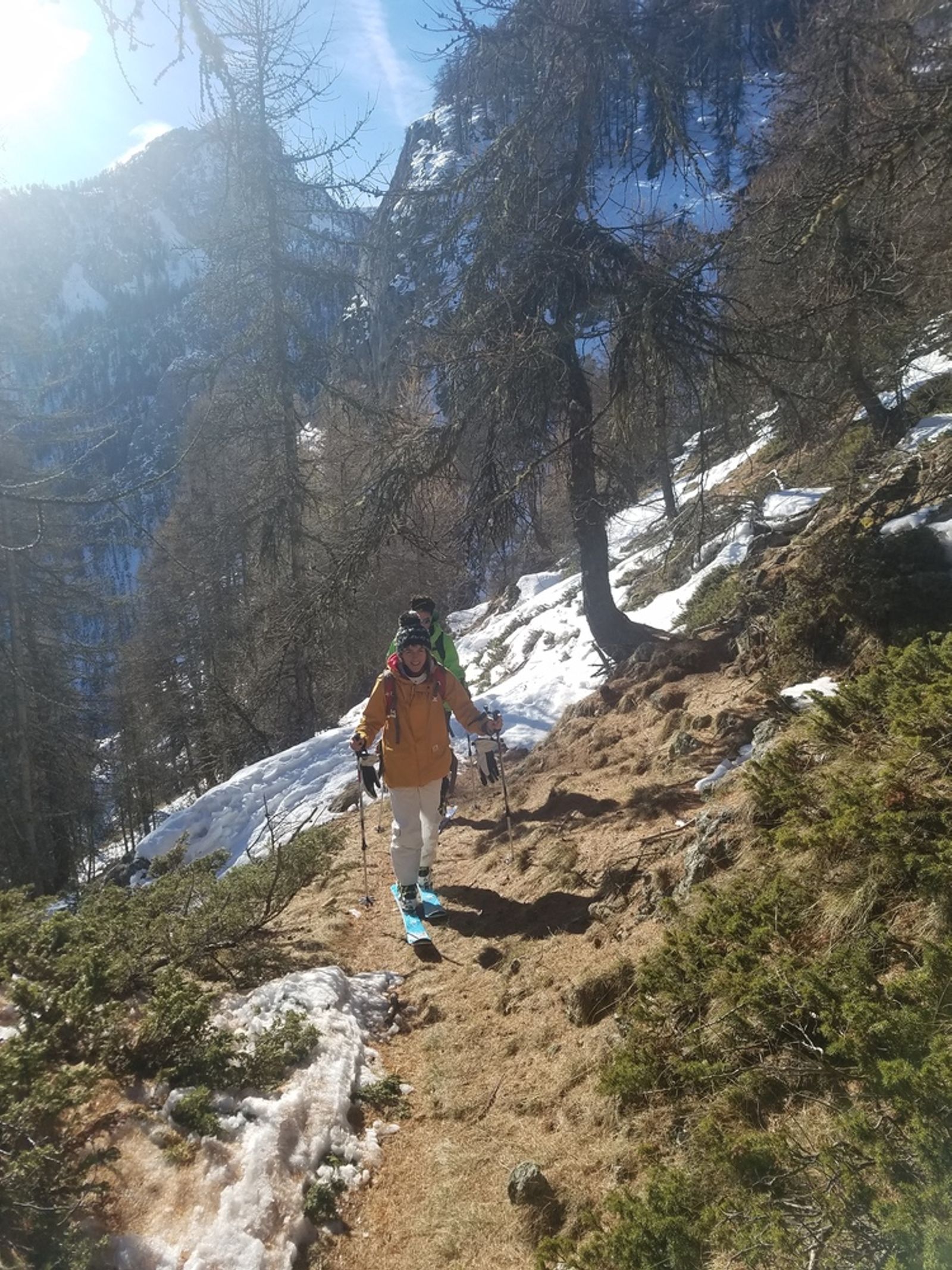 Skieur à la montée sur un chemin déneigé
