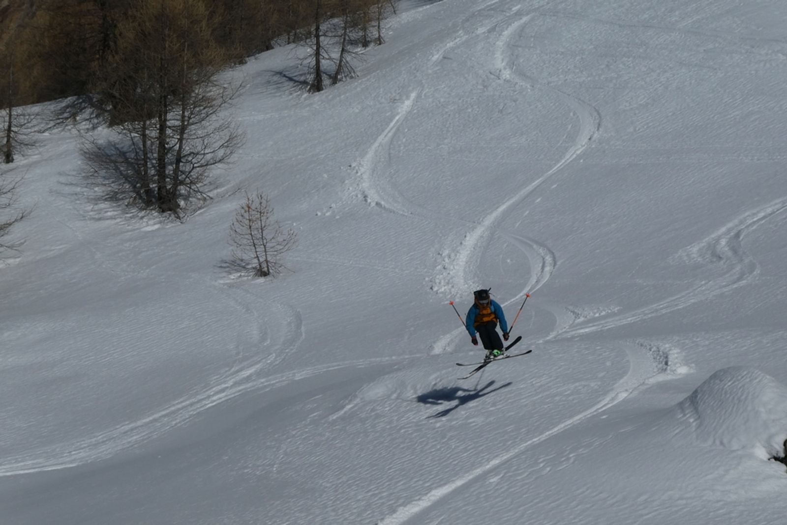 Skieur traçant une courbe dans la poudreuse sous la Tête de Gaulent.
