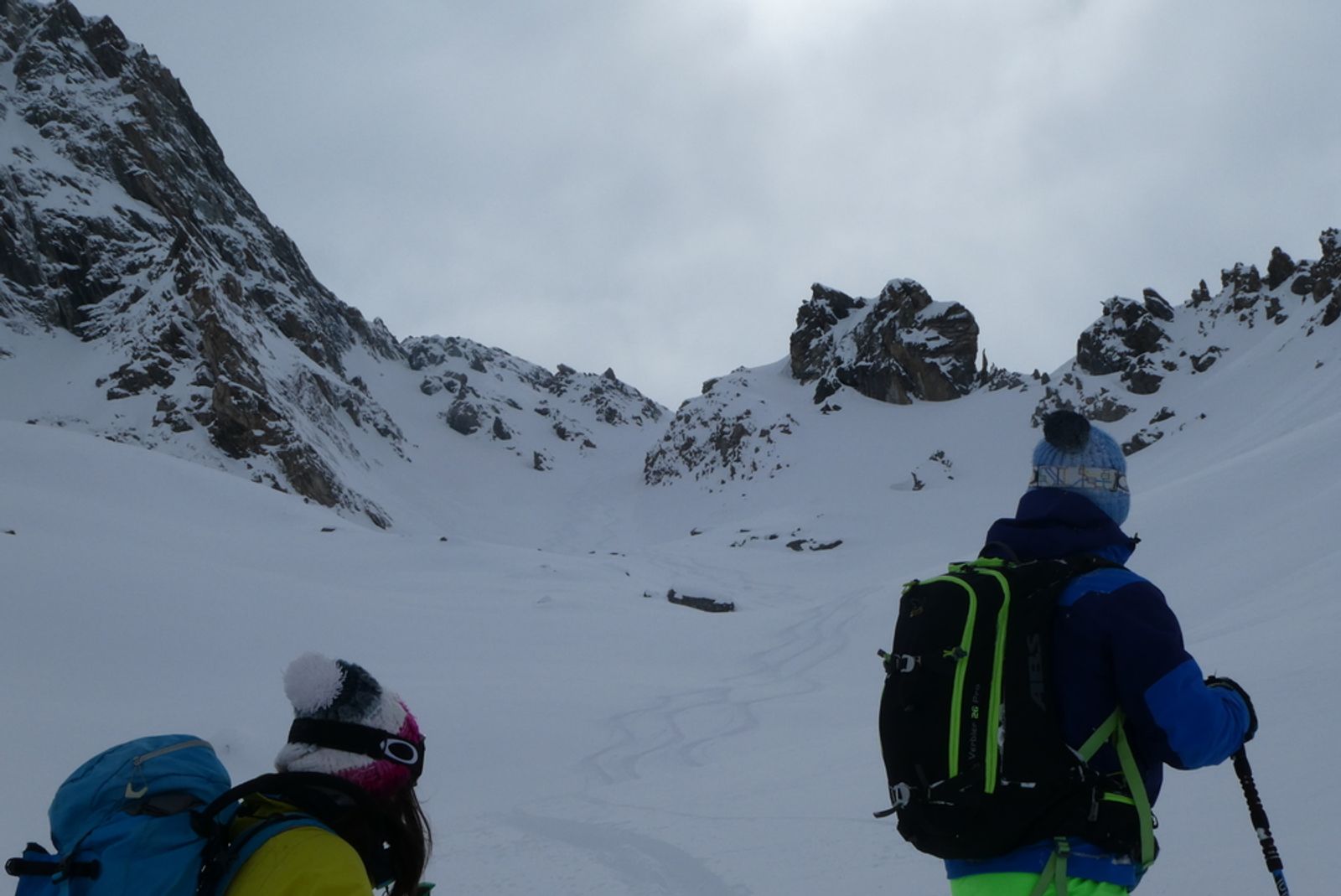 A couple of skiers gaze at their tracks in a couloir in the Queyras