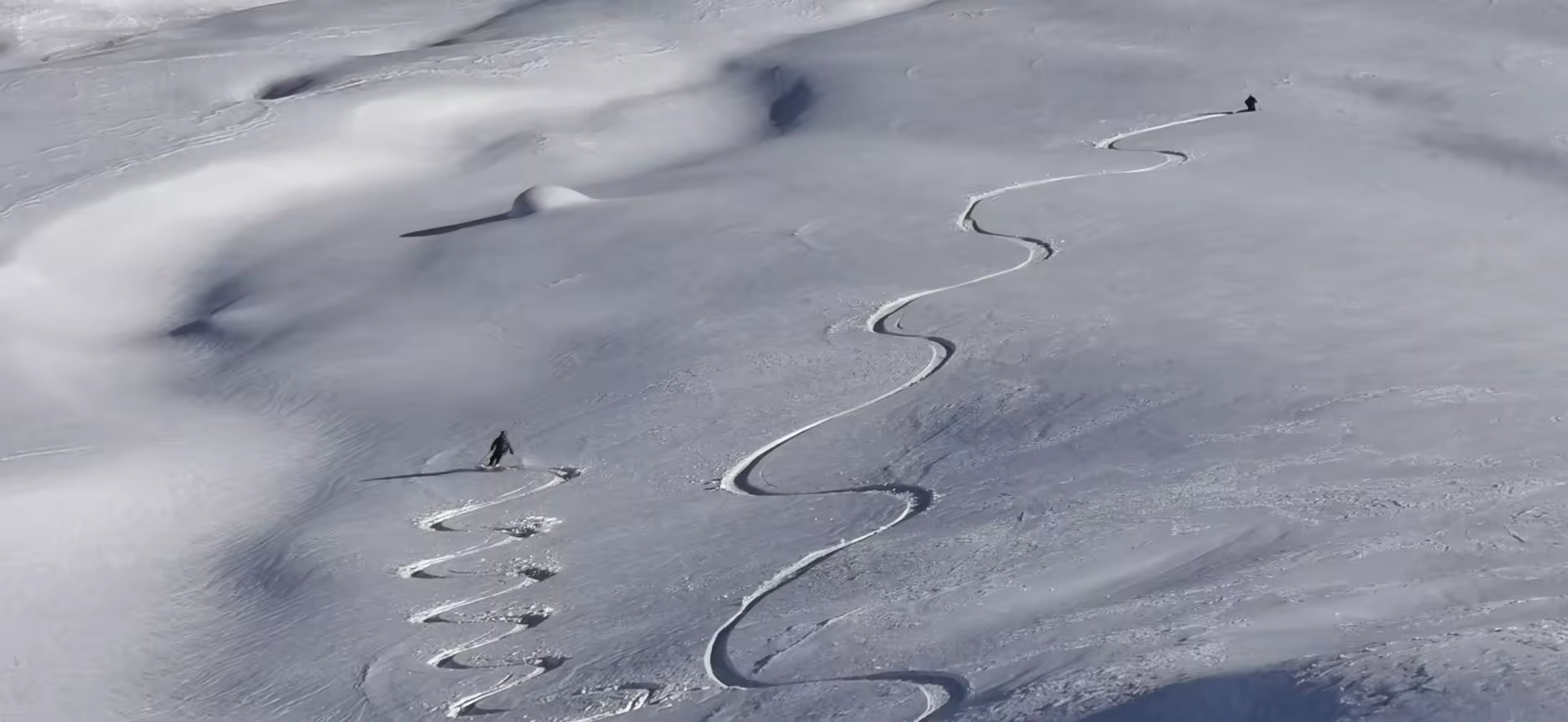 Skieurs faisant des traces différentes dans des belles pentes poudreuse