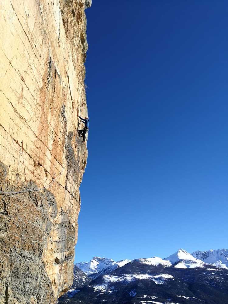 Un grimpeur en tête qui se déciupe dans le ciel bleu dans une longueur très verticale au ponteil