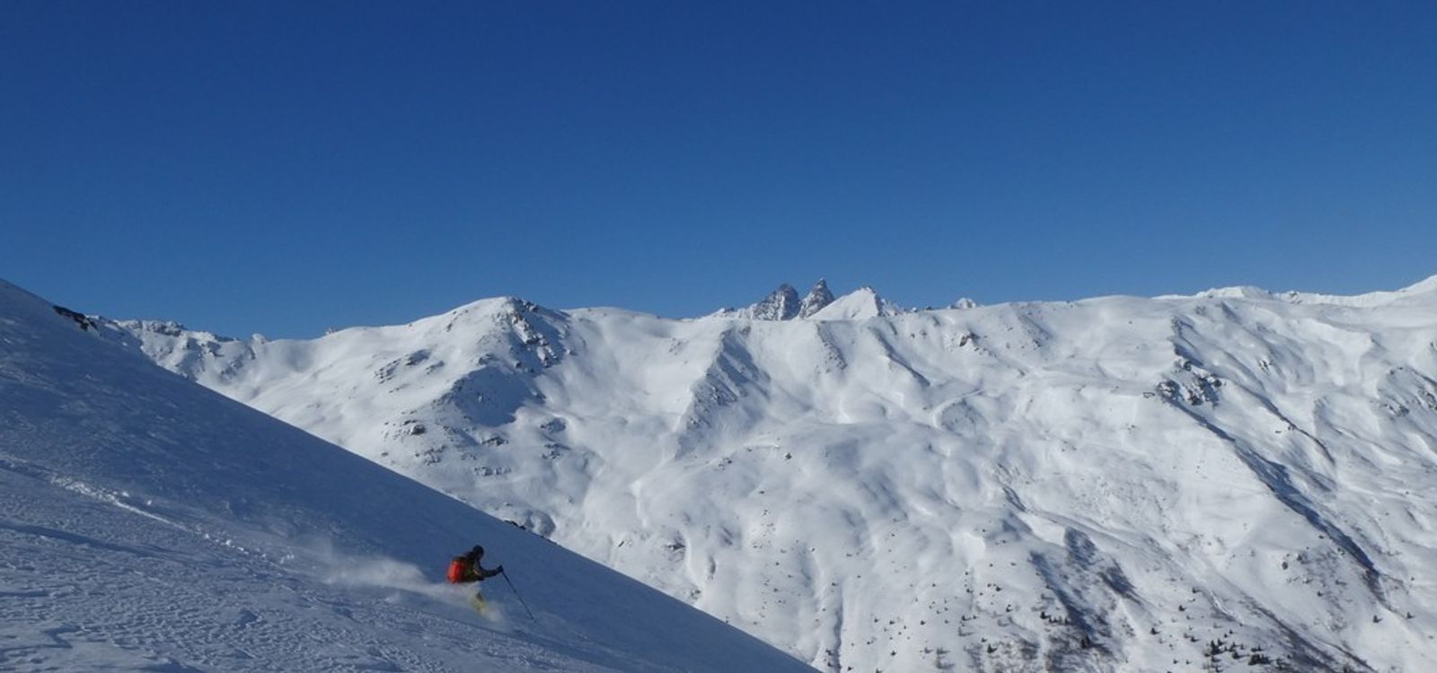 Skieur dans le panorama enneigé sous le Becquot