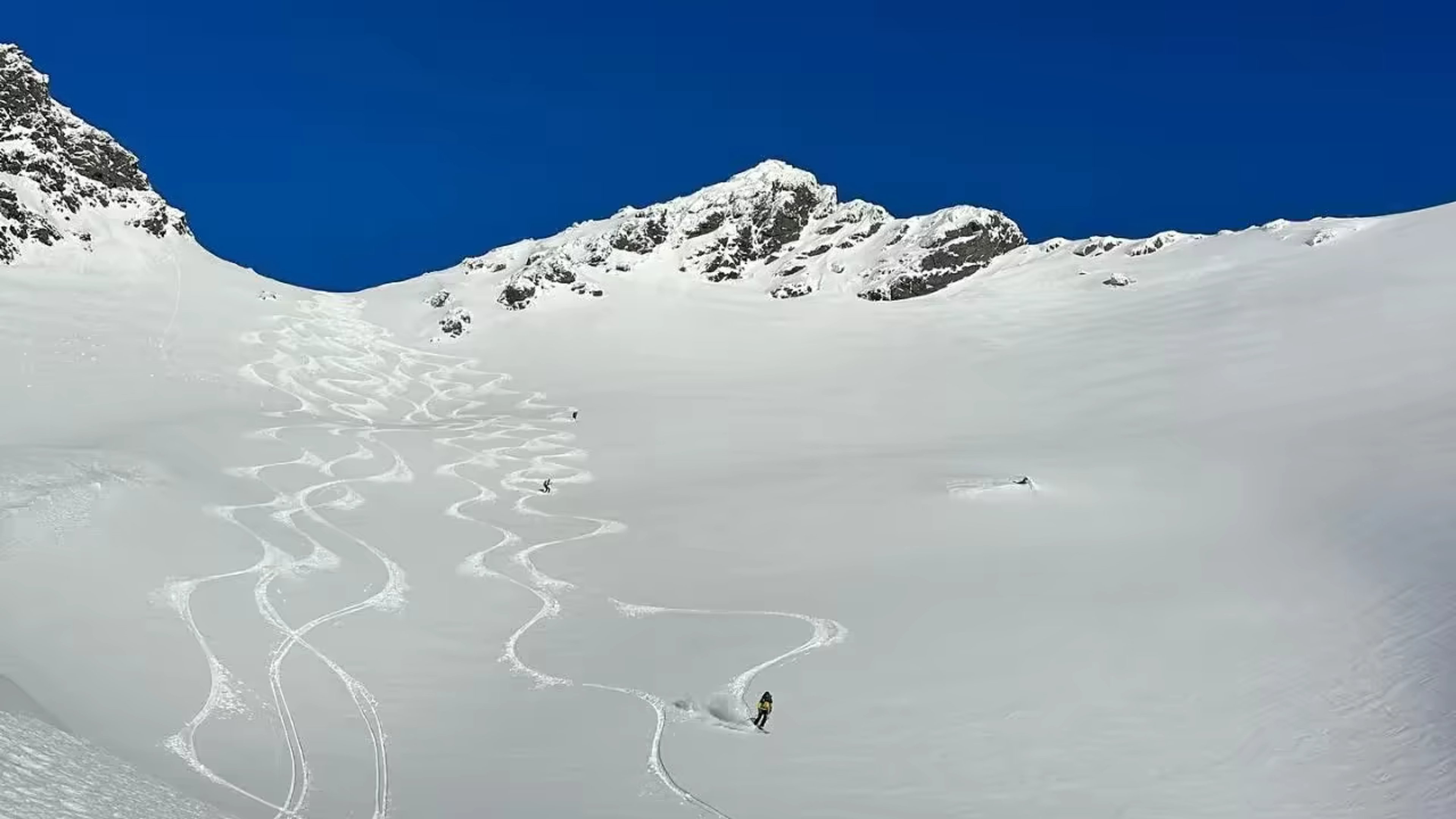 Skieur traçant une vaste pente de poudreuse pendant un voyage ski-voile en Norvège