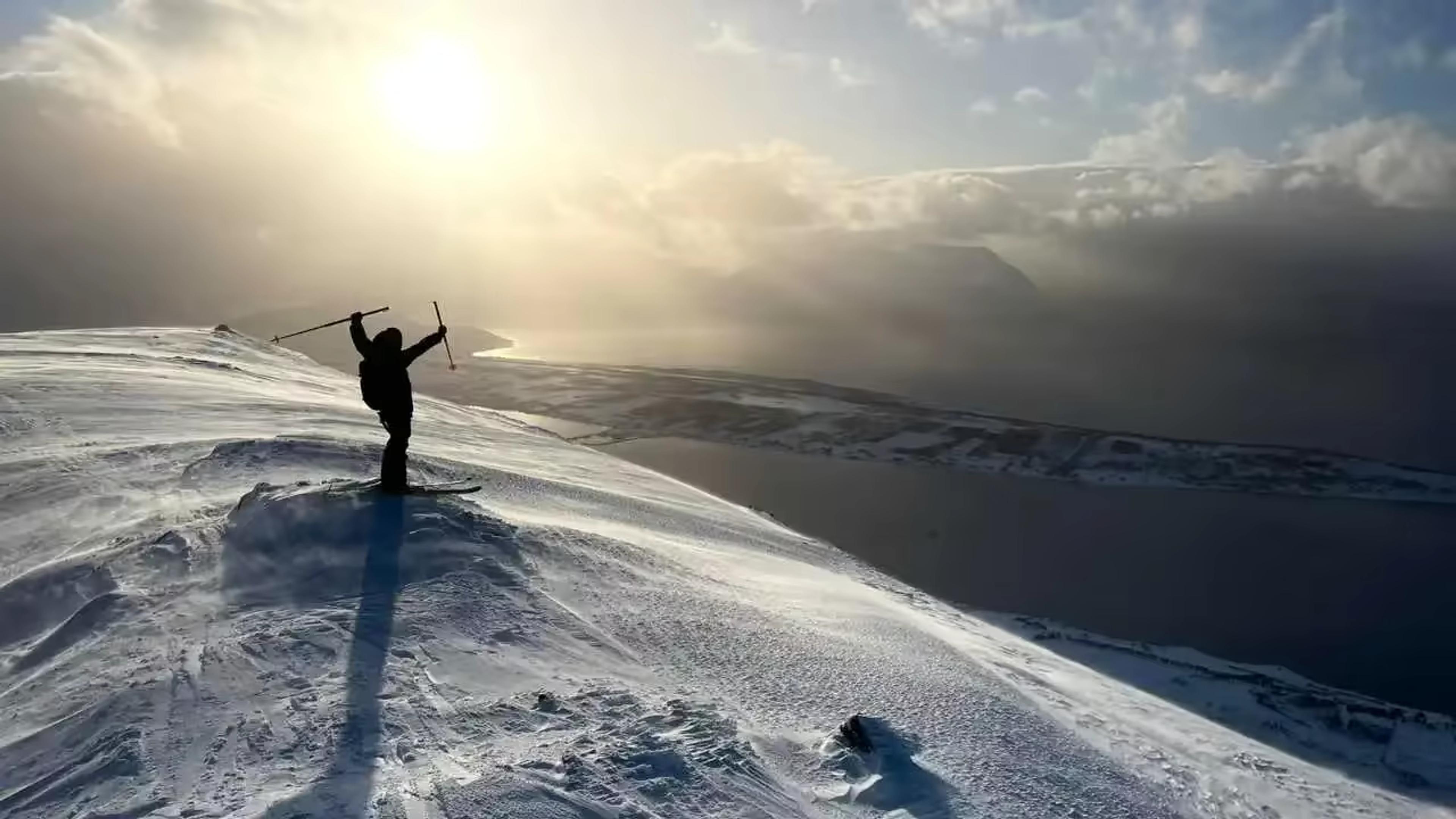 Skieur au sommet d’une montagne dominant les fjords de Norvège
