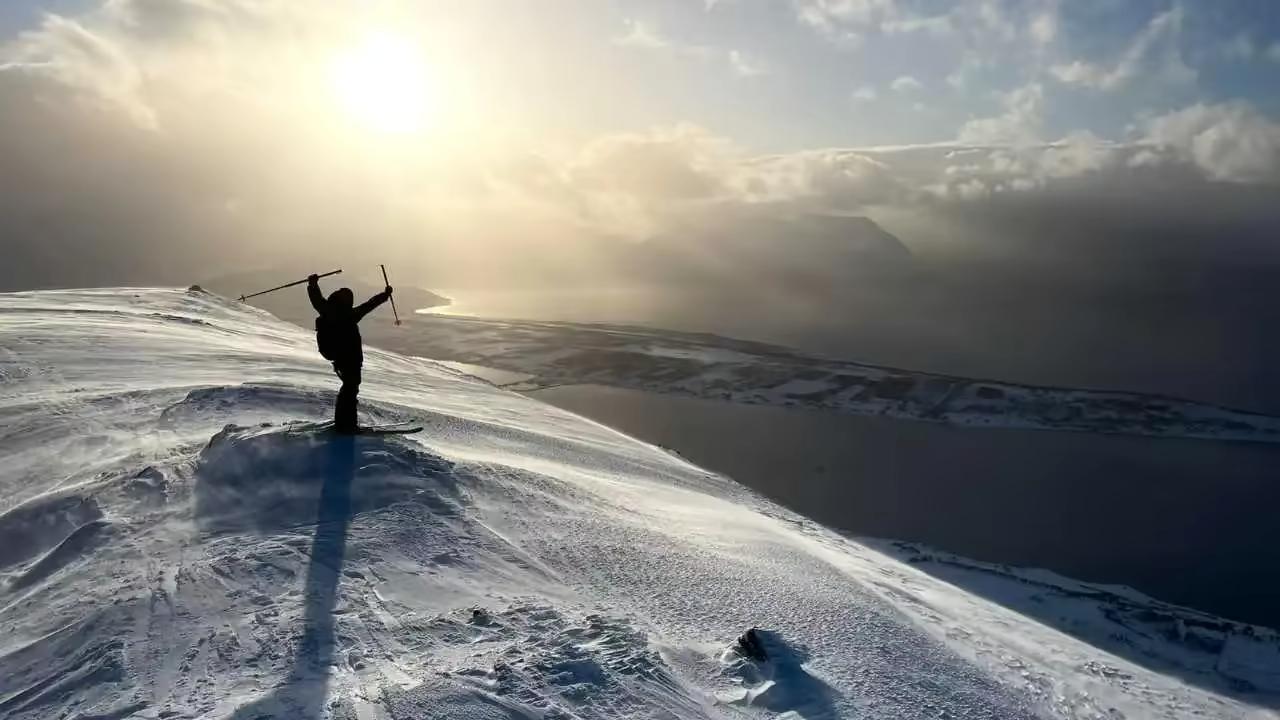 Skieur au sommet d’une montagne dominant les fjords de Norvège