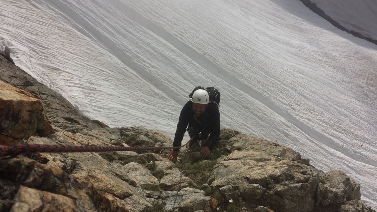 Alain dans la deuxième longueur rocheuse d’accès au pilier Anne, au-dessus d’un névé.