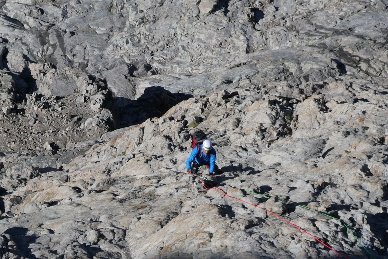 Ivan grimpe dans les dalles de granit du Bastion sur la voie Chapoutot, en face sud de la Meije.