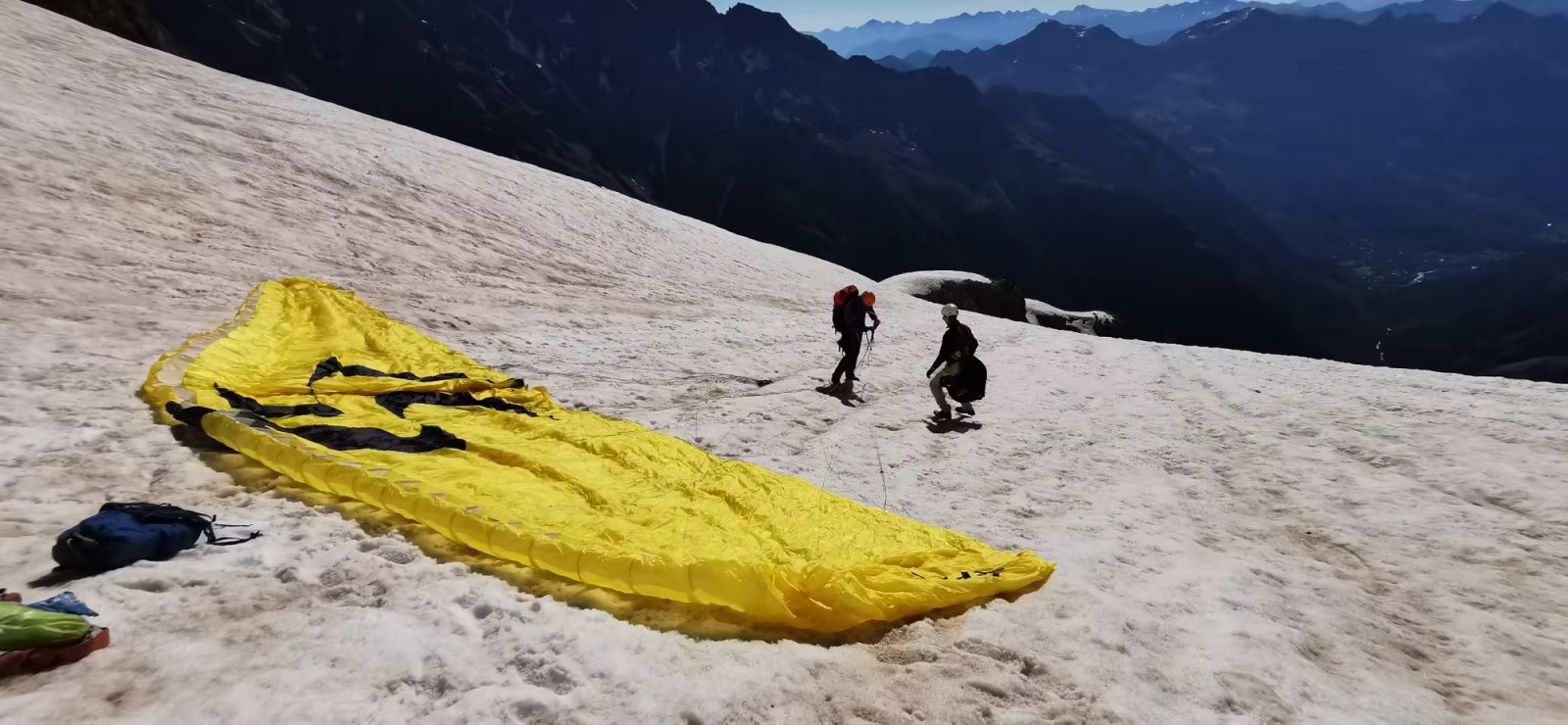 Alpinistes préparant une voile de parapente sur les pentes enneigées du Pelvoux