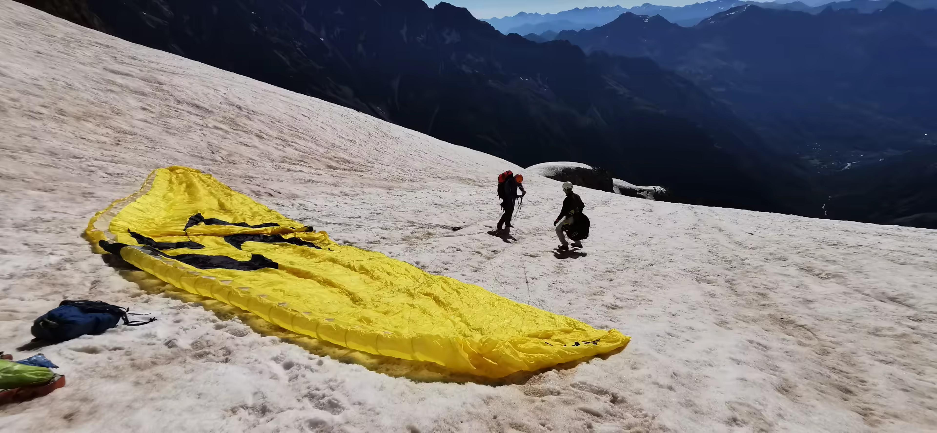 Alpinistes préparant une voile de parapente sur les pentes enneigées du Pelvoux