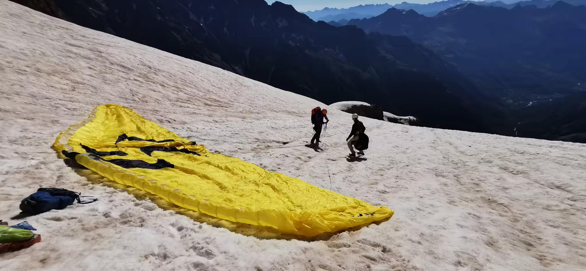 Alpinistes préparant une voile de parapente sur les pentes enneigées du Pelvoux