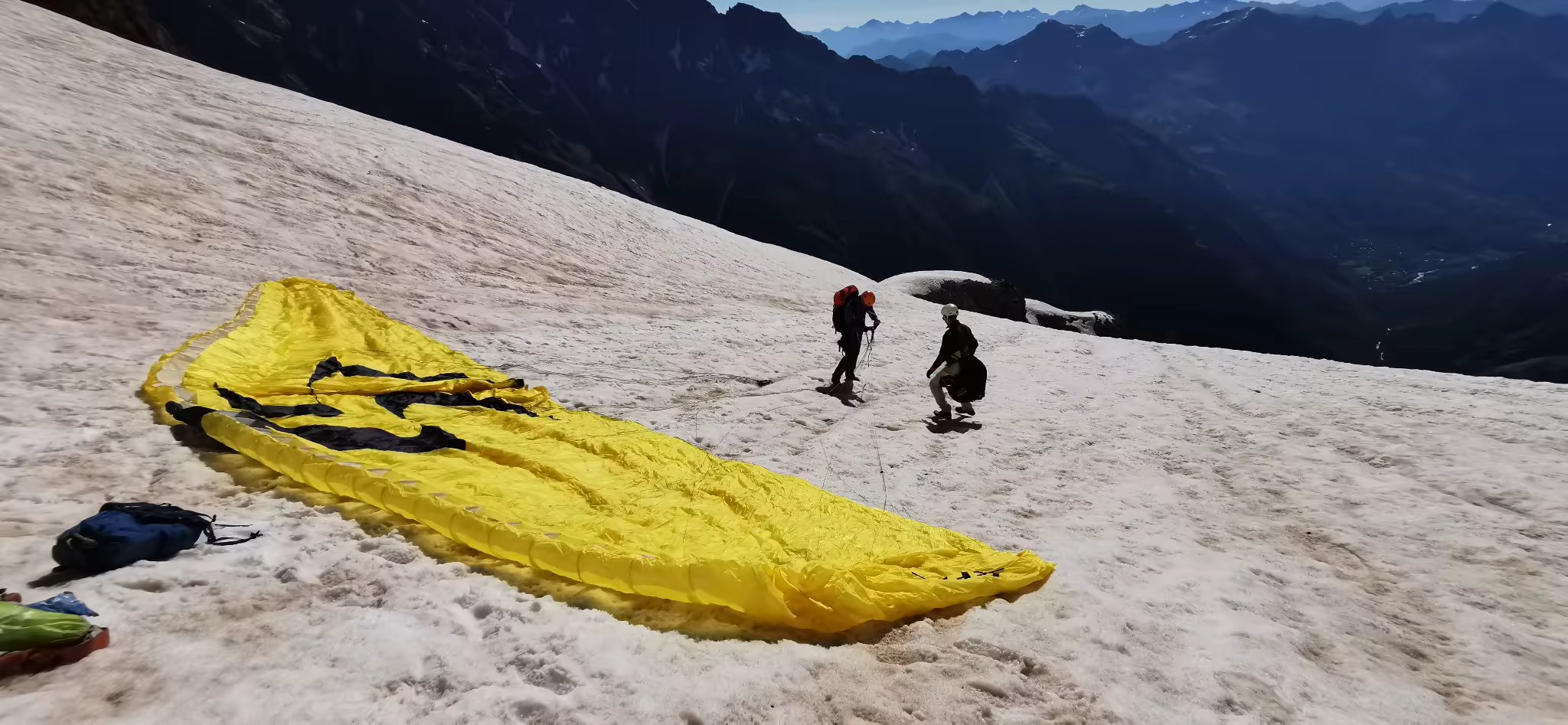 Alpinistes préparant une voile de parapente sur les pentes enneigées du Pelvoux