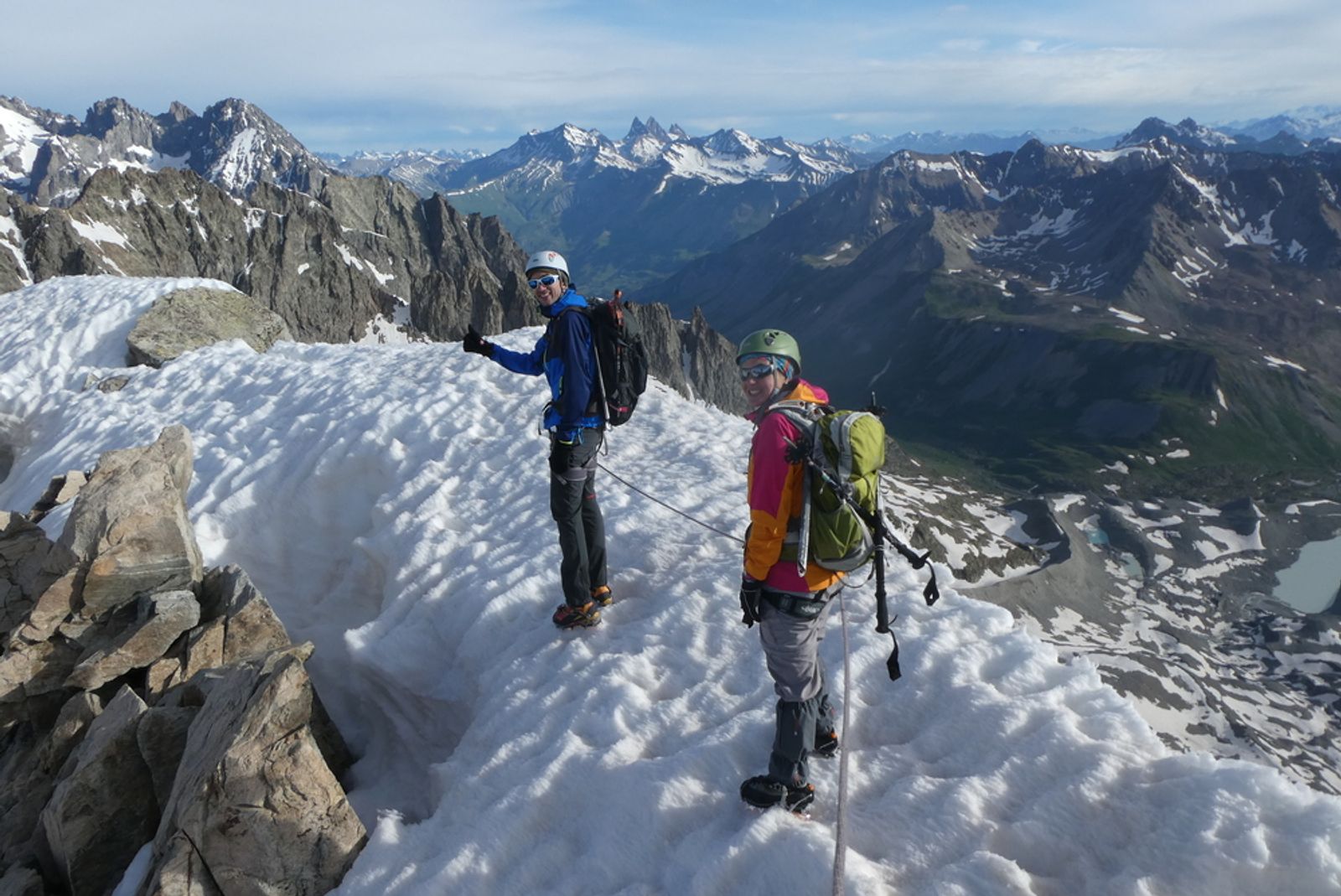 Deux alpinistes casqués sur une arête enneigée du pic du Glacier d’Arsine, au-dessus des vallées des Écrins.