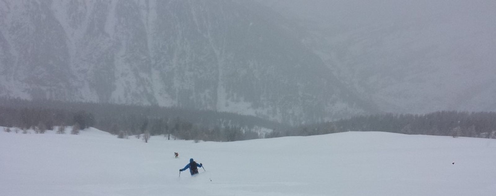 Skieur en veste bleue dans une vaste pente enneigée à Maloqueste.