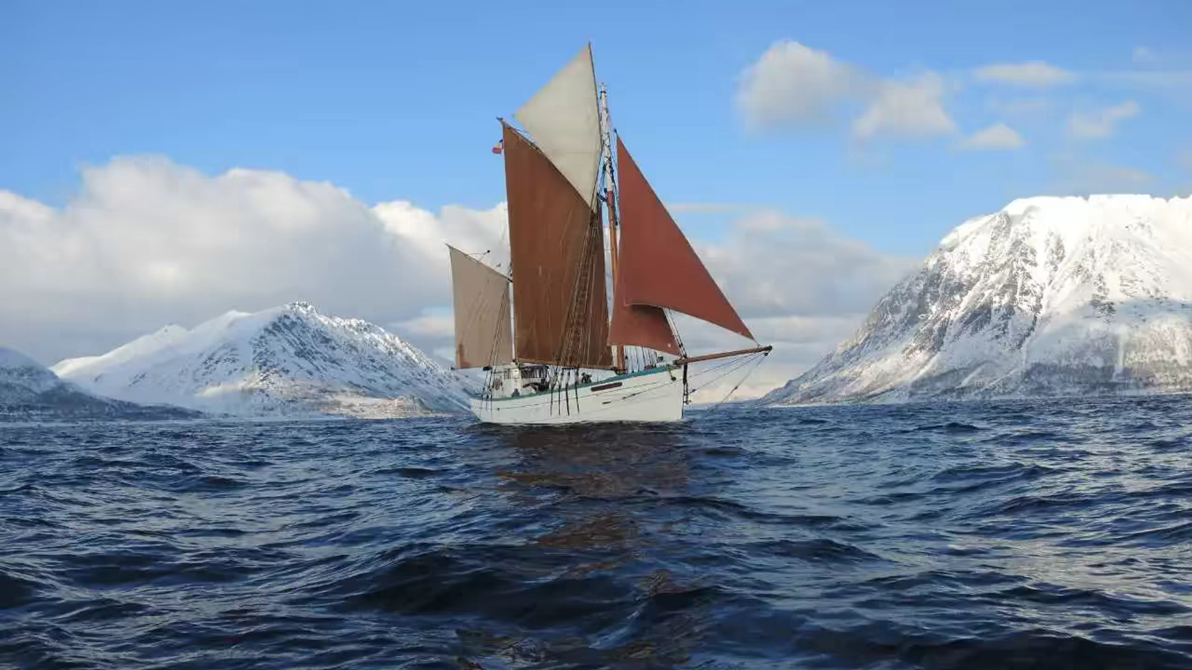 Le Fleur de Lampaul navigue sous voiles entre les montagnes enneigées de Norvège