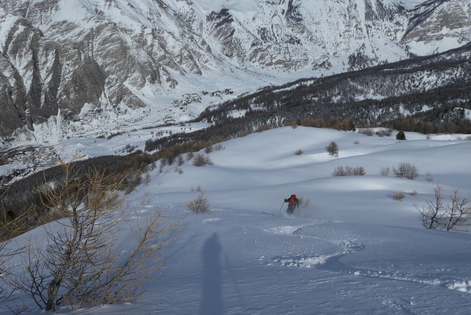 Skieur qui fait de beaux virages dans le dernier hors piste de la journée