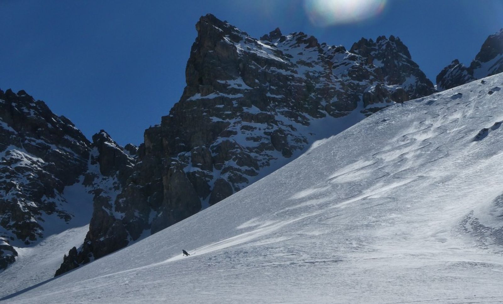 Ski dans un grand champ de poudreuse avec des montagnes rocheuses autour